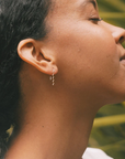 Silver wavy earrings shown on a model