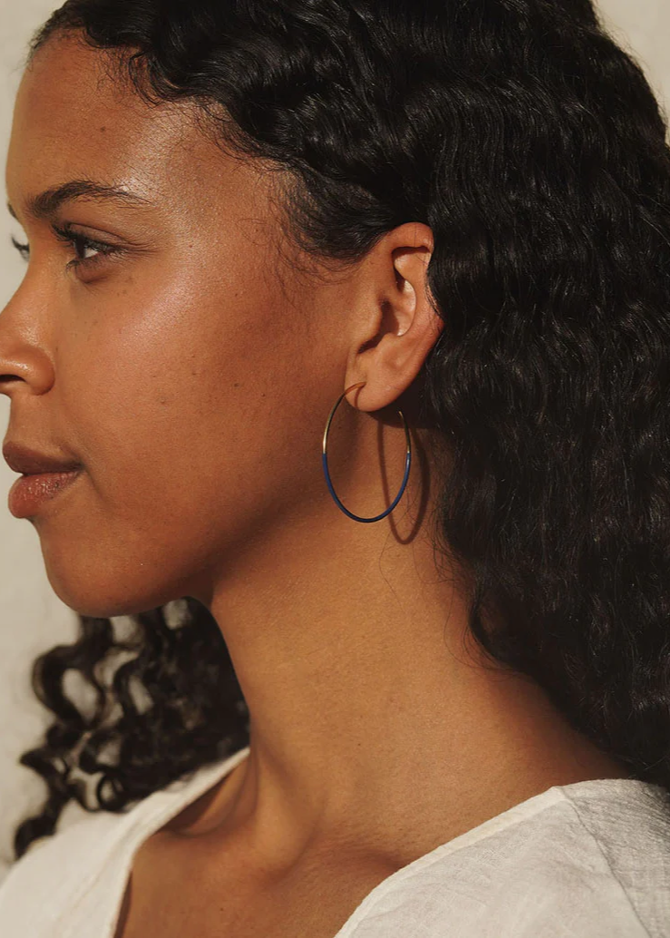 Gold and cobalt blue hoop earrings by Baleen shown on a model