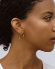 Gold deco style hoops worn by a model