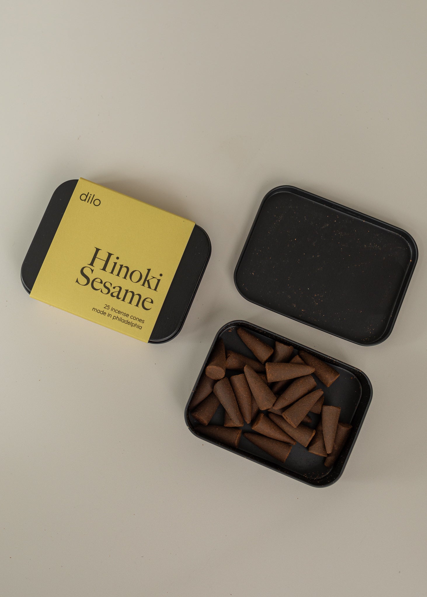 Incense box one closed stating "hinoki Sesame" and one opened next to it on a cream background