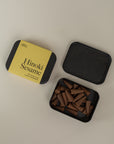 Incense box one closed stating "hinoki Sesame" and one opened next to it on a cream background