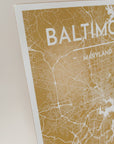 Close-up of golden yellow print map of baltimore with a light pink background