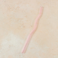 Flatlay of a pink wavy reusable straw.