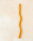 Flatlay of an orange wavy reusable straw. 