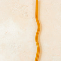 Flatlay of an orange wavy reusable straw.