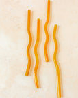 Flatlay of an orange wavy reusable straw. 