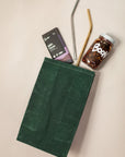 Emerald Eco-Friendly Lunch Bag with Boon Sauce, two reusable straws and Raaka Chocolate coming Out From Bag