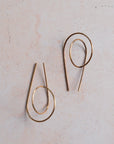 Pair of gold hoop earrings on a light beige background