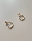 gold hoops as a flay lay on a beige background