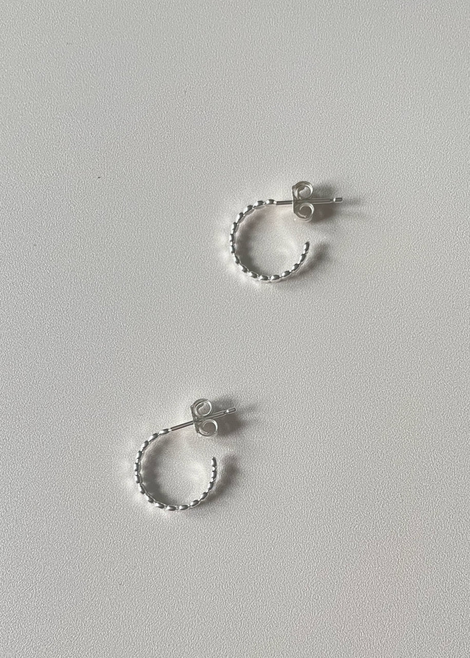 Two sterling silver hoop earrings on a white background