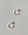 Two sterling silver hoop earrings on a white background