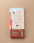 backside flatlay of the coconut milk chocolate bar by Raaka with details on the ingredients, why they use unroasted chocolate, and nutrition facts