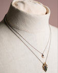Necklace with a pendant on a mannequin bust against a neutral background