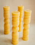 Group of sculpted beeswax candles with on a beige background