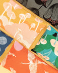 flat lay of a variety of eye pillows ranging from mushroom illustrations, flowers, and birds