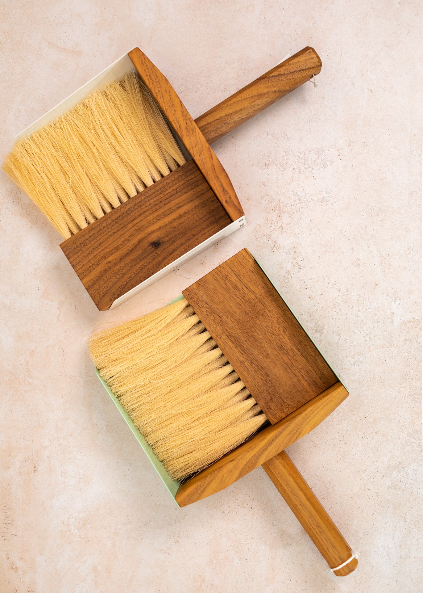 flatlay photo of two dust pan sets, white on top and the mint set on the bottom