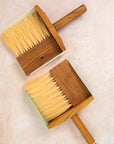 flatlay photo of two dust pan sets, white on top and the mint set on the bottom