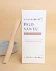 box of palo santo sticks with one leaning against it