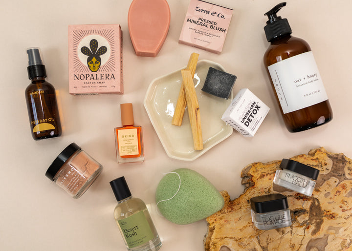 Flatlay of indie wellness goods, such as natural candles, sustainable deodorizer, organic soap and more