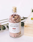 Jar of Nourish Bath Salts with Flowers Surrounding