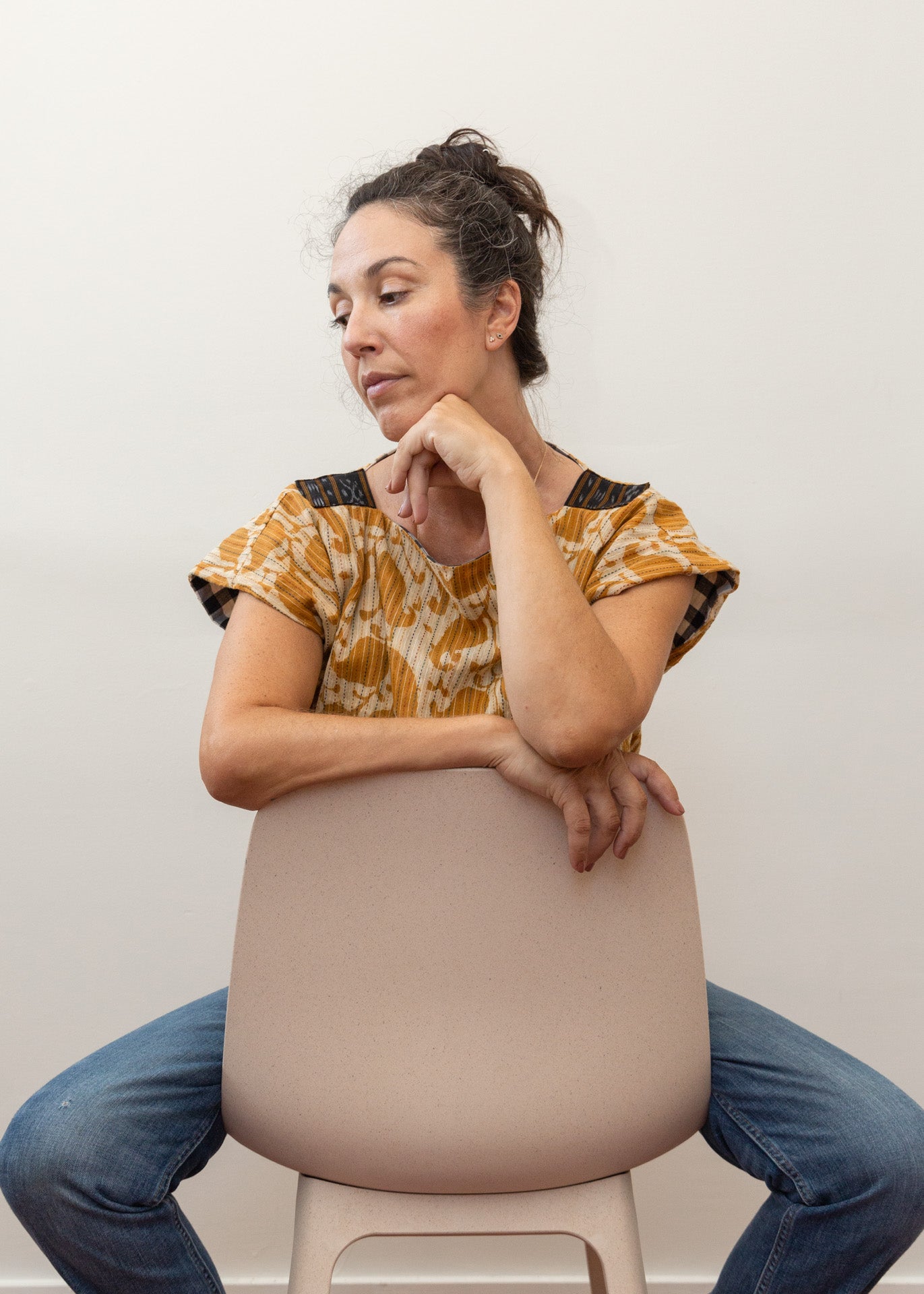 photo of a woman wearing the reversed mustard yellow color sitting on a chair backwards