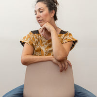photo of a woman wearing the reversed mustard yellow color sitting on a chair backwards