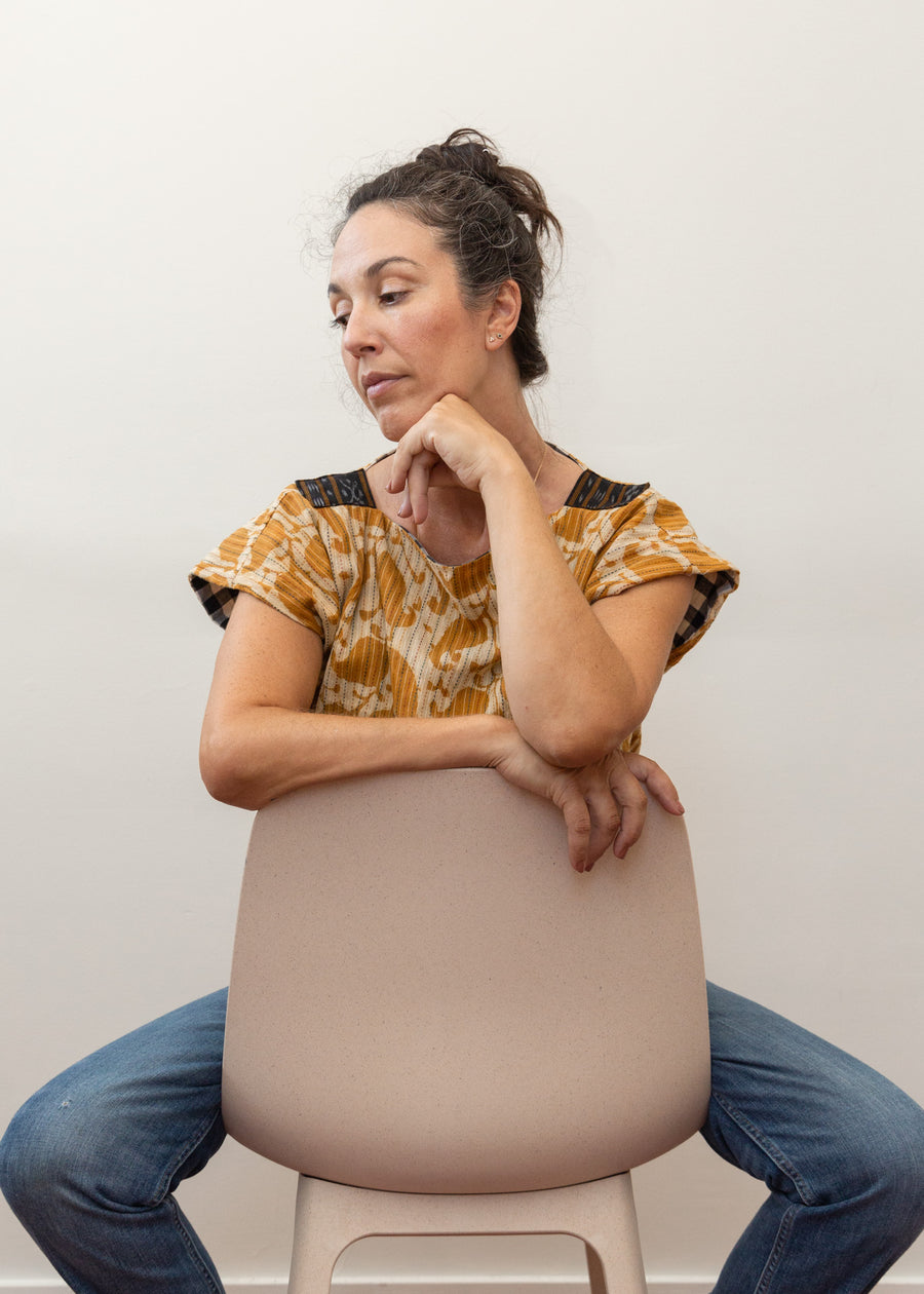 photo of a woman wearing the reversed mustard yellow color sitting on a chair backwards