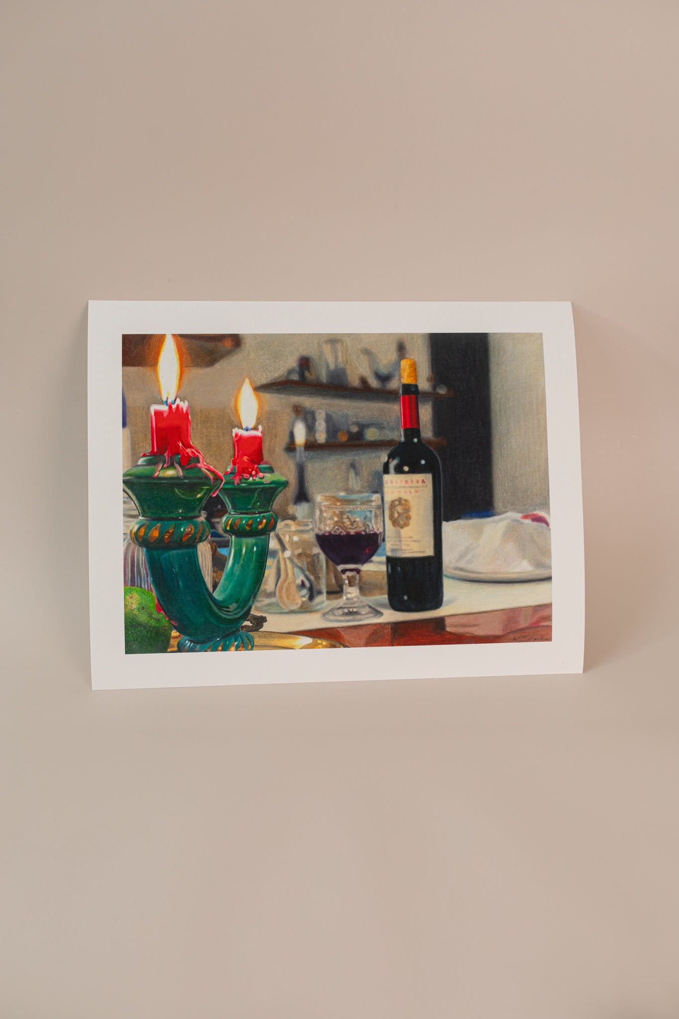 Photo of an art print for an italian series of a bottle of wine with a candle holder in the foreground. Print is on a light pink background