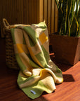 Lime green, cream and mustard blanket falling out of a basket
