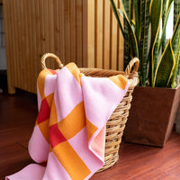 Photo of a pink & orange blanket falling out of a basket
