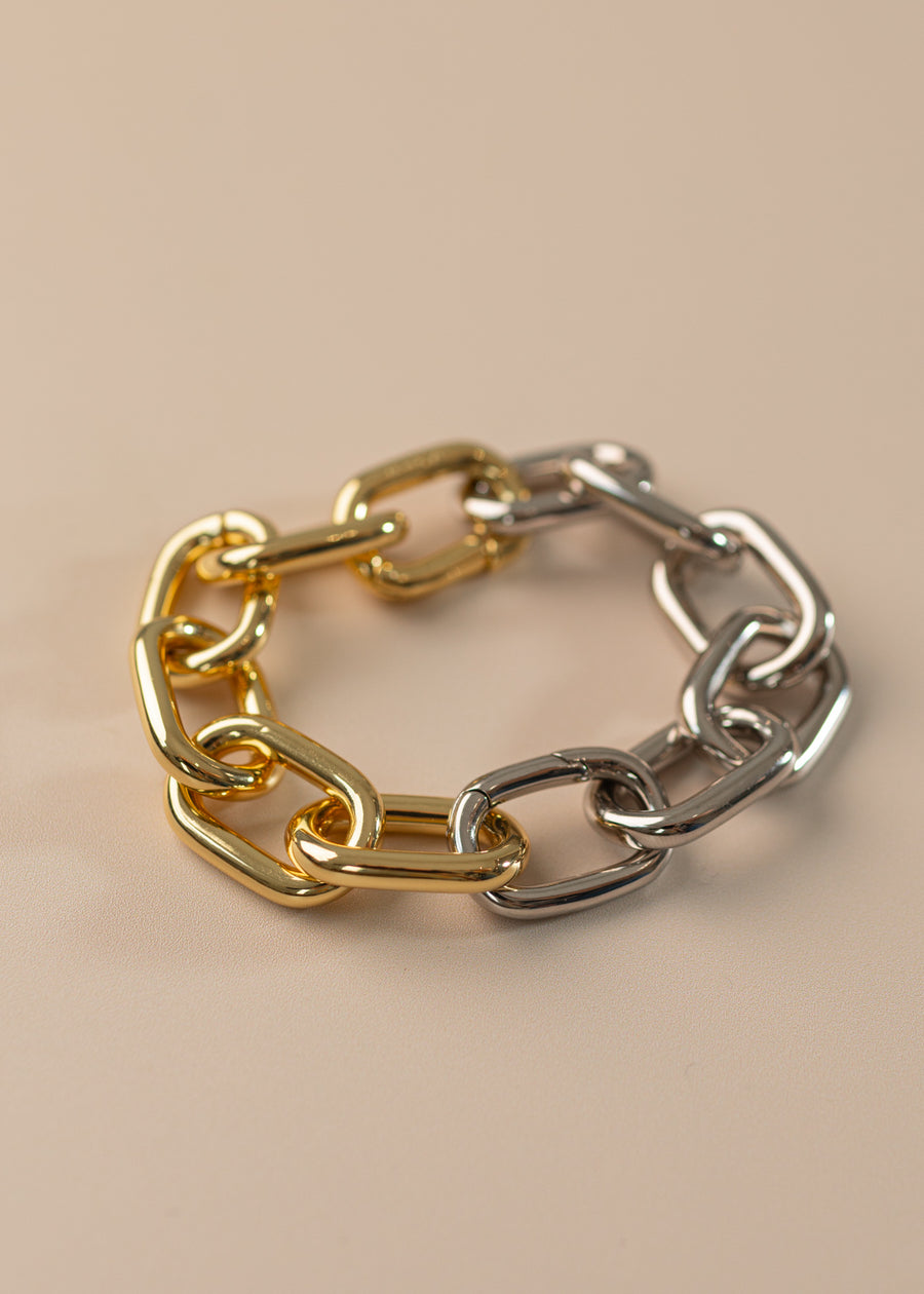 Photo of link bracelet, half silver half gold on a peach background