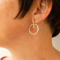 Close-up of a mixed metal earring on a models earlobe
