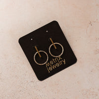 flat-lay of mixed metal earrings on a black jewelry card