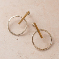 Close-up of two Mixed metal earrings on a light pink background