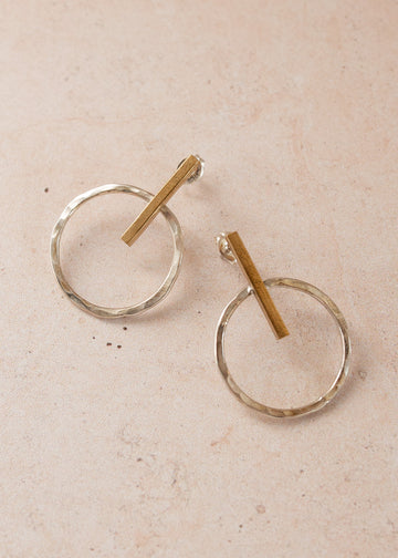 Close-up of two Mixed metal earrings on a light pink background