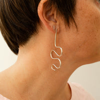 Squiggle statement earring in sterling silver on a models ear