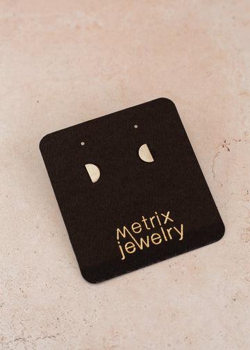 flat-lay of semi-circle silver studs on a black jewelry card