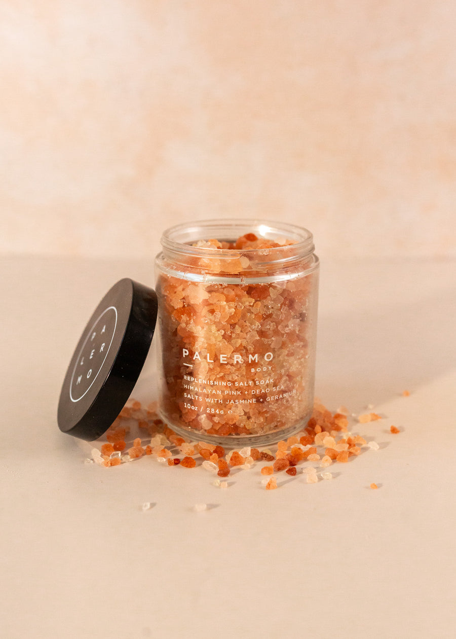 Palermo salt in a clear jar, with pink, red and clear salt crystals surrounding the jar