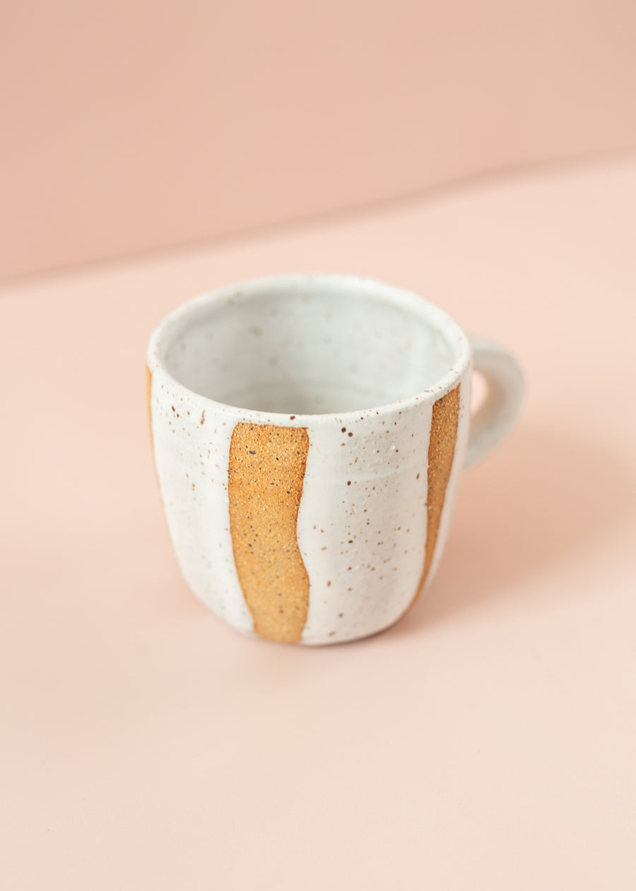 Ceramic mug with white glaze around the mug, with hints of original clay color showing. 