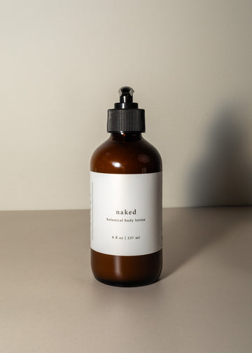 Minimal pump bottle in amber with a white label, on a plain cream background