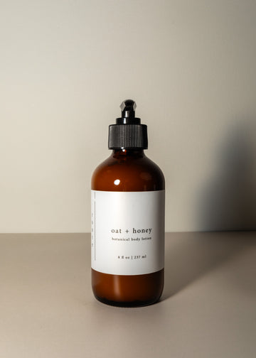 Minimal pump bottle in amber with a white label, on a plain cream background