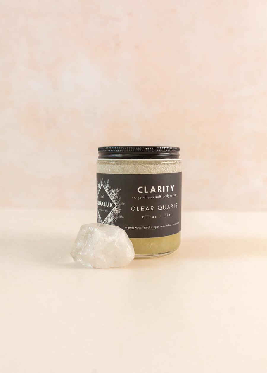 Jar of sea salt body scrub with a clear quartz on the side 