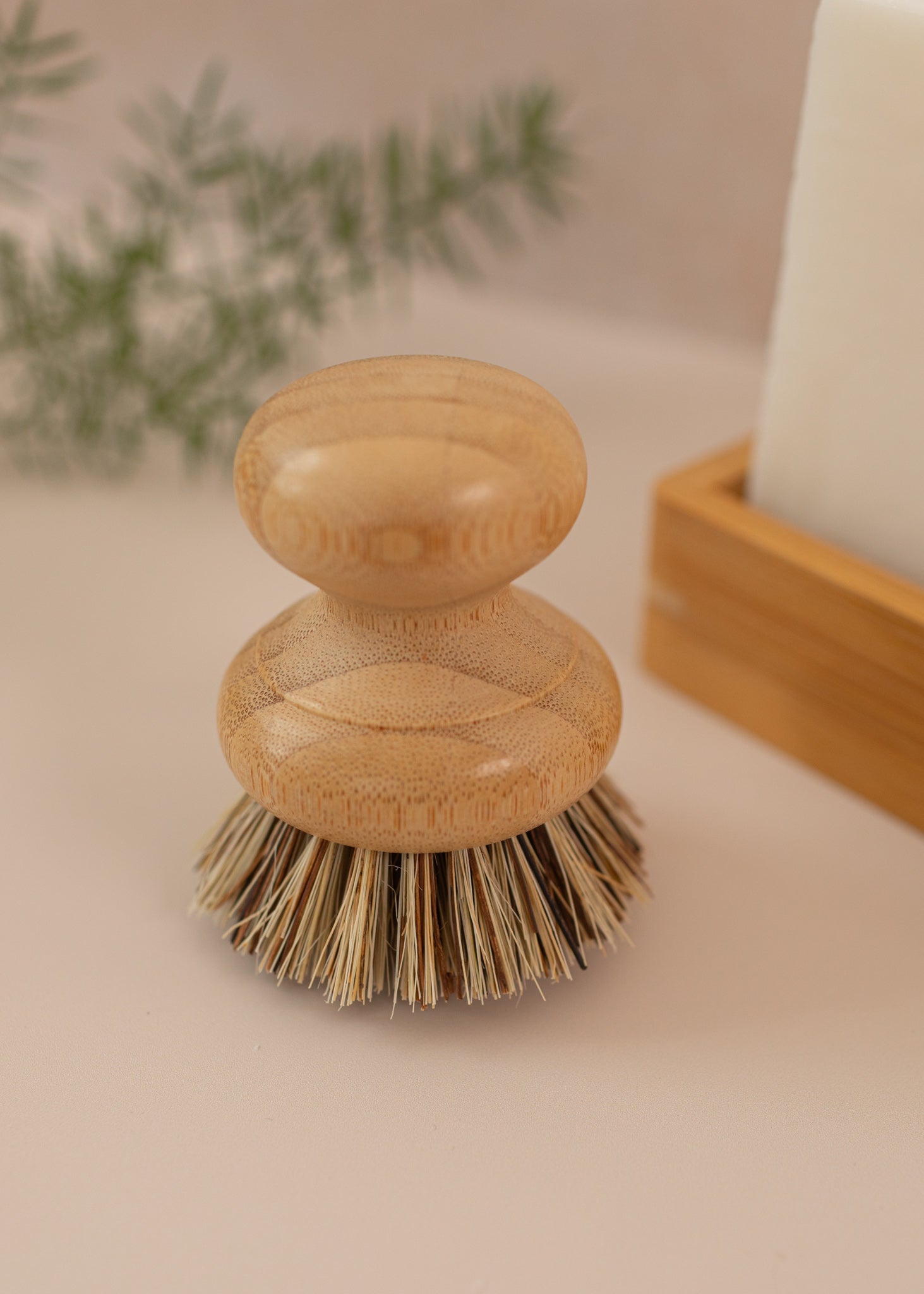 Close-up of dish brush on a light pink background