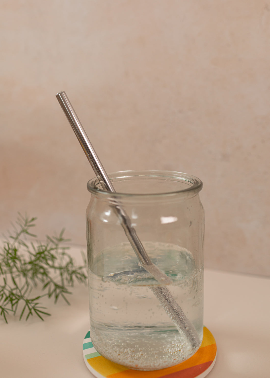photo of a straight, silver reusable straw in a mason jar