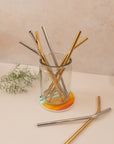 glass of silver and gold variety of reusable straws