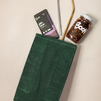 Emerald Eco-Friendly Lunch Bag with Boon Sauce, two reusable straws and Raaka Chocolate coming Out From Bag