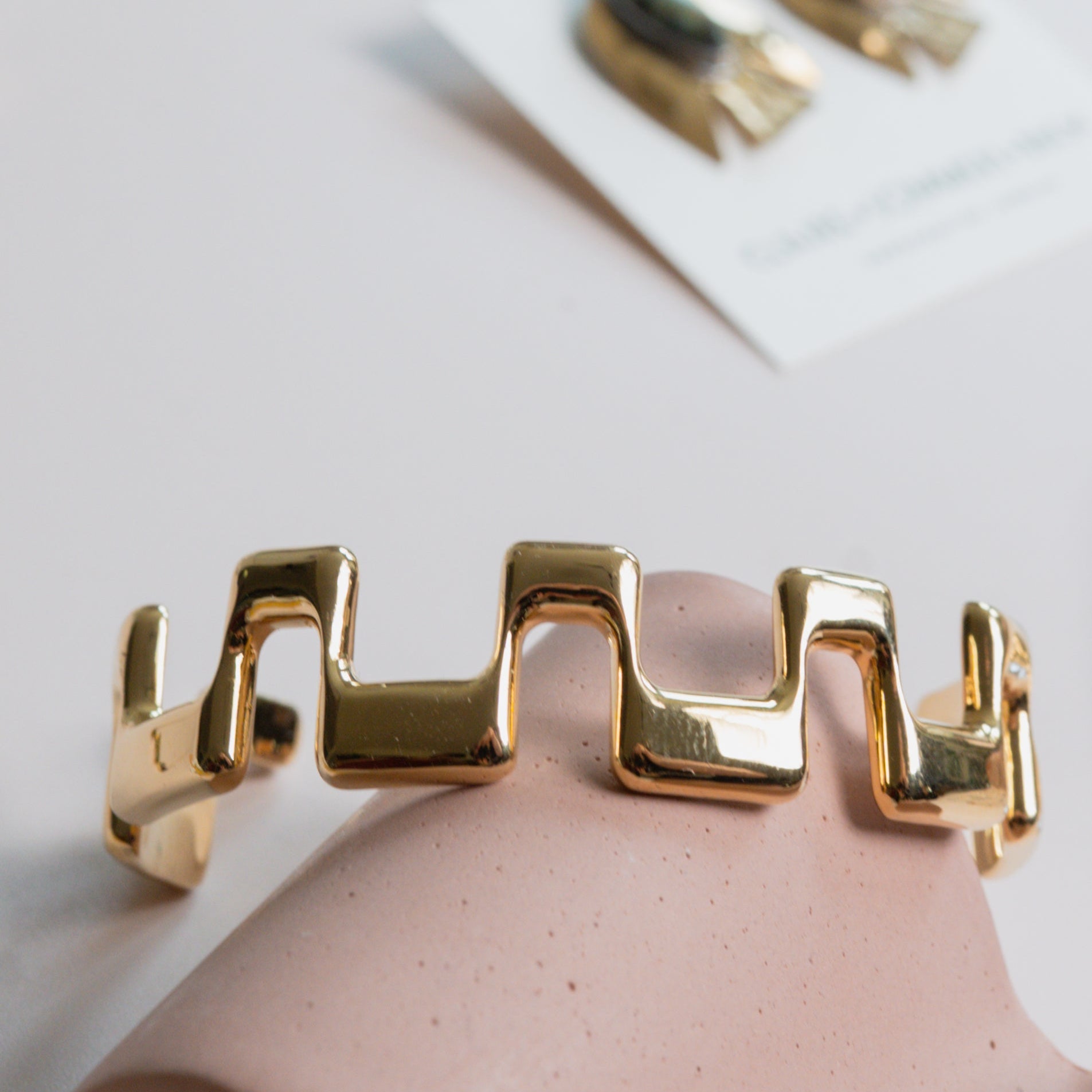 Gold bracelet on a display with a blurred background