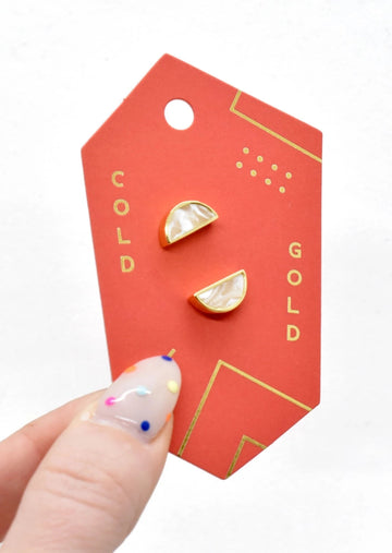 Model Holding Jewelry Card with Gold Moon Studs In Crystal Quartz