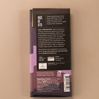 backside flatlay of the 100% cacao chocolate bar by Raaka with details on the ingredients, why they use unroasted chocolate, and nutrition facts