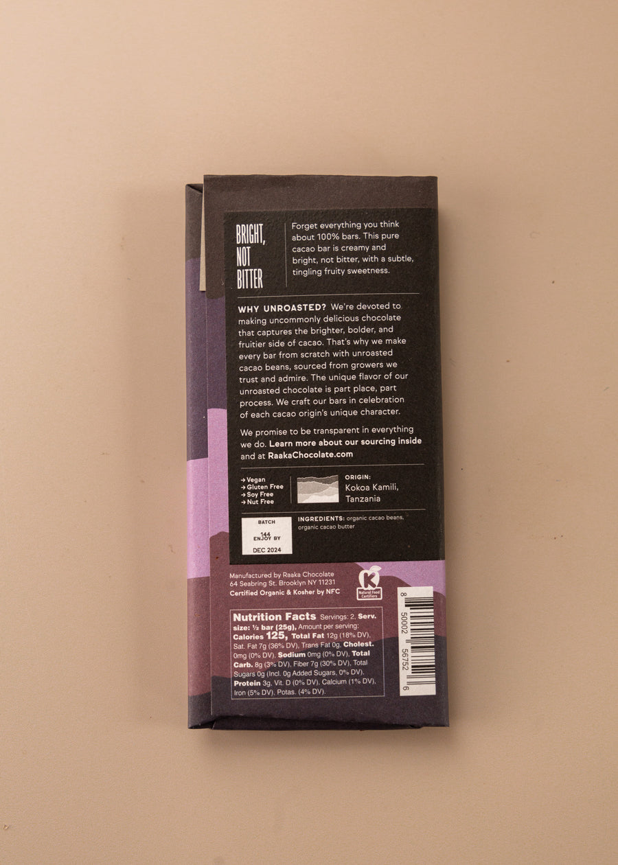 backside flatlay of the 100% cacao chocolate bar by Raaka with details on the ingredients, why they use unroasted chocolate, and nutrition facts